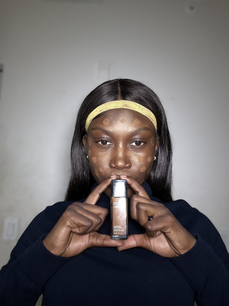 dark skin woman using maybelline fit me foundation