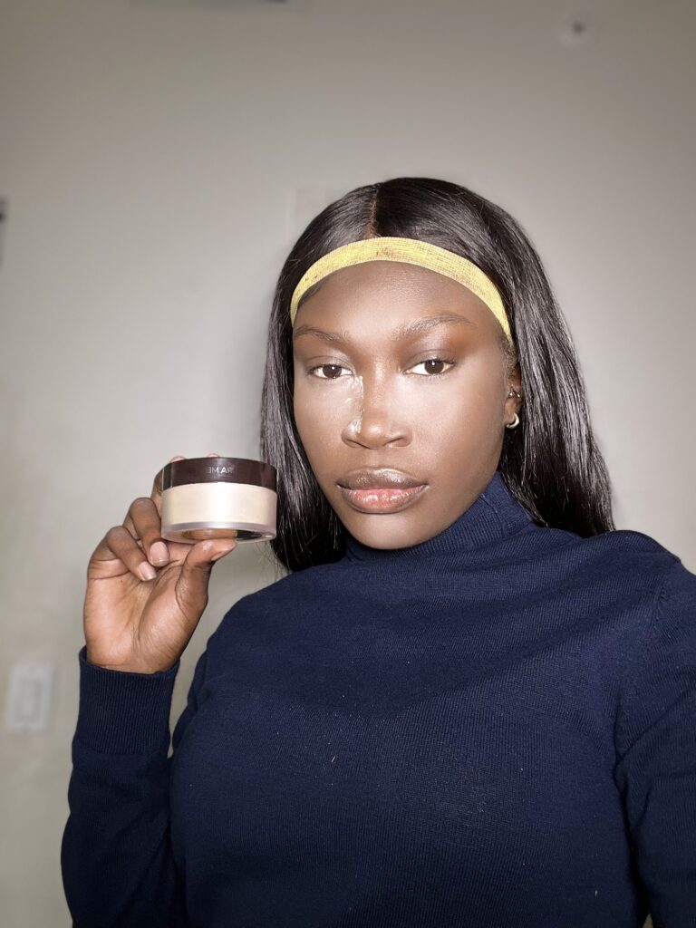 dark skin black woman using laura mercier honey translucent powder 