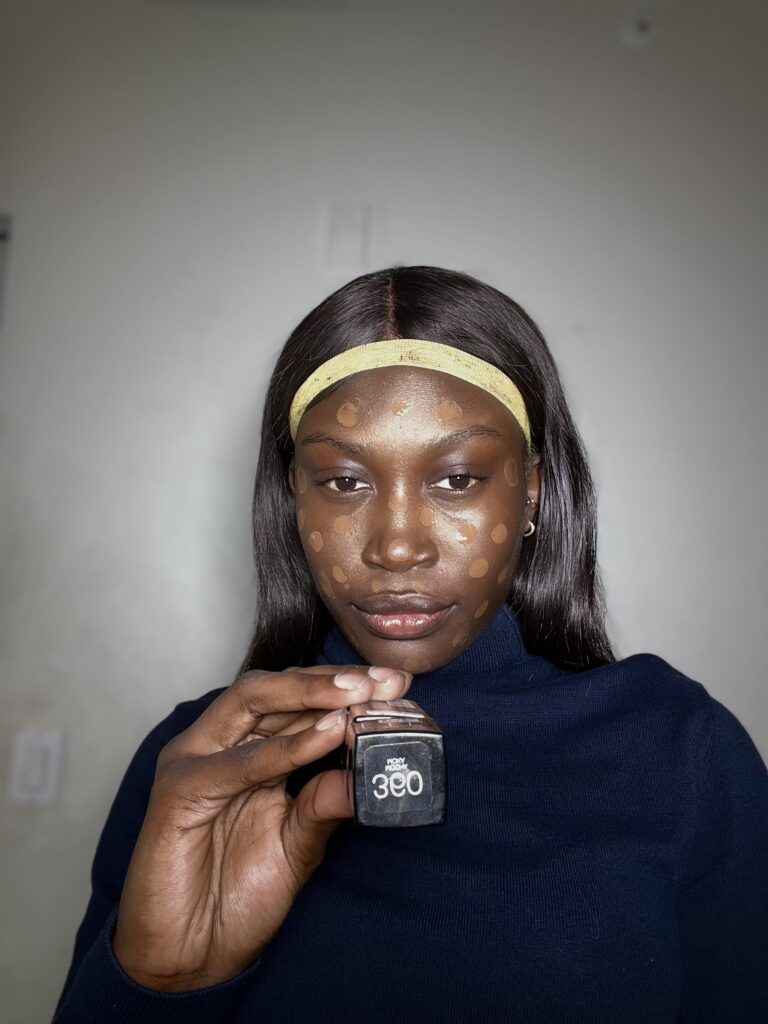 dark skin woman using maybelline fit me foundation