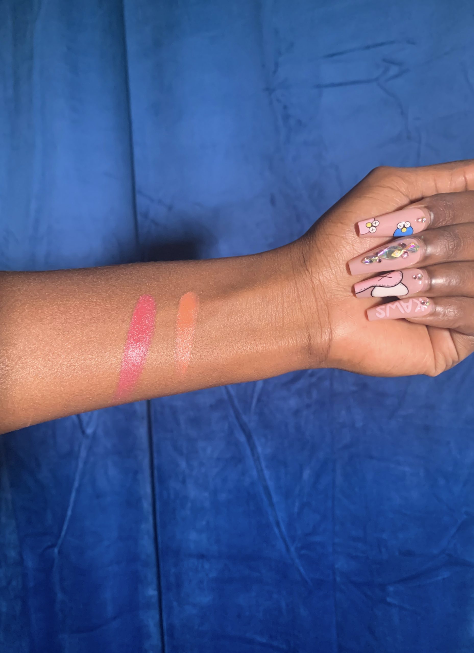 Black woman showing swatches of tower 28 cream blushes